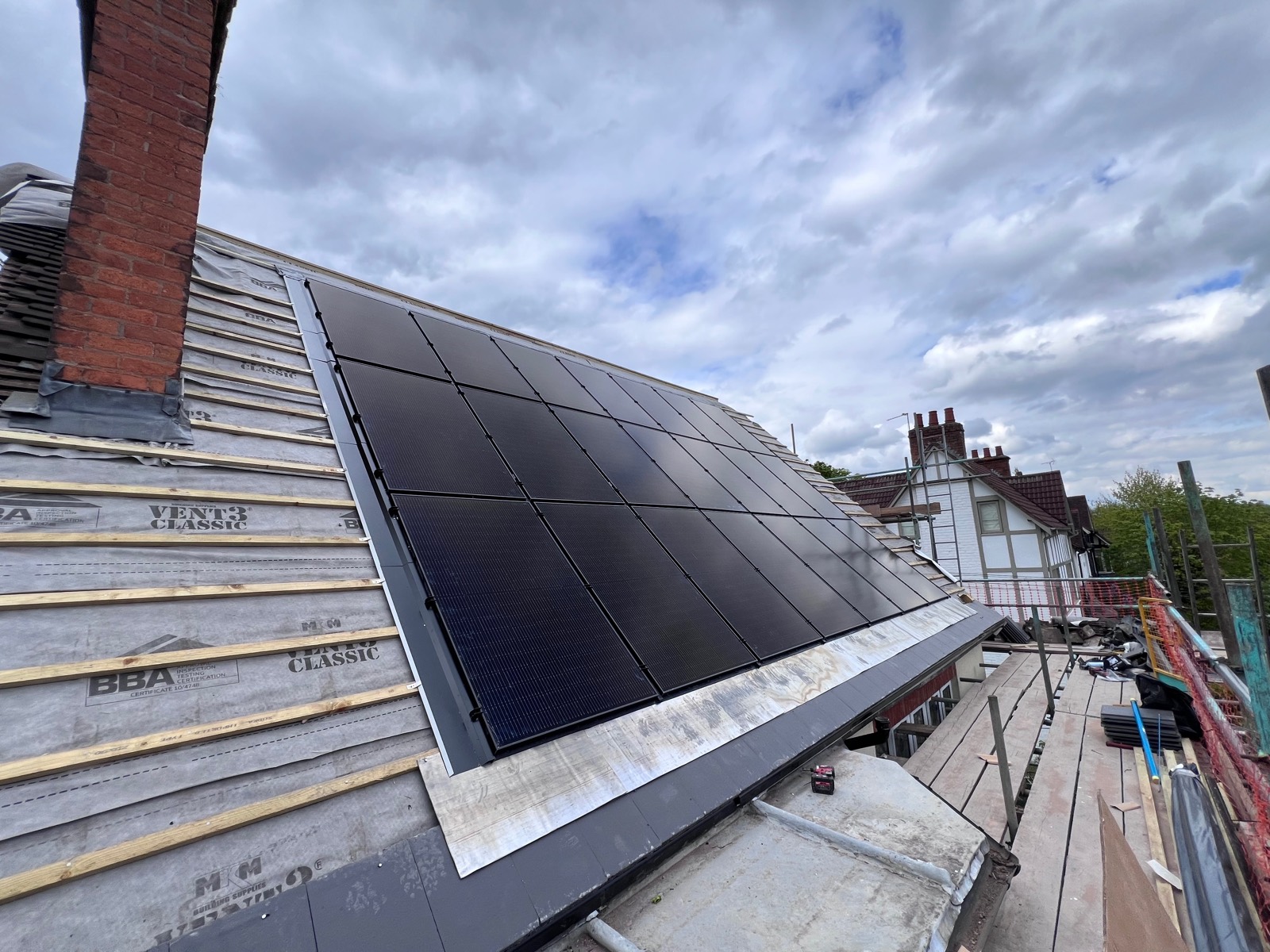 Next, the panels drop into the trays and sit flush in the roof plane — here mid-install with the underlay still visible.