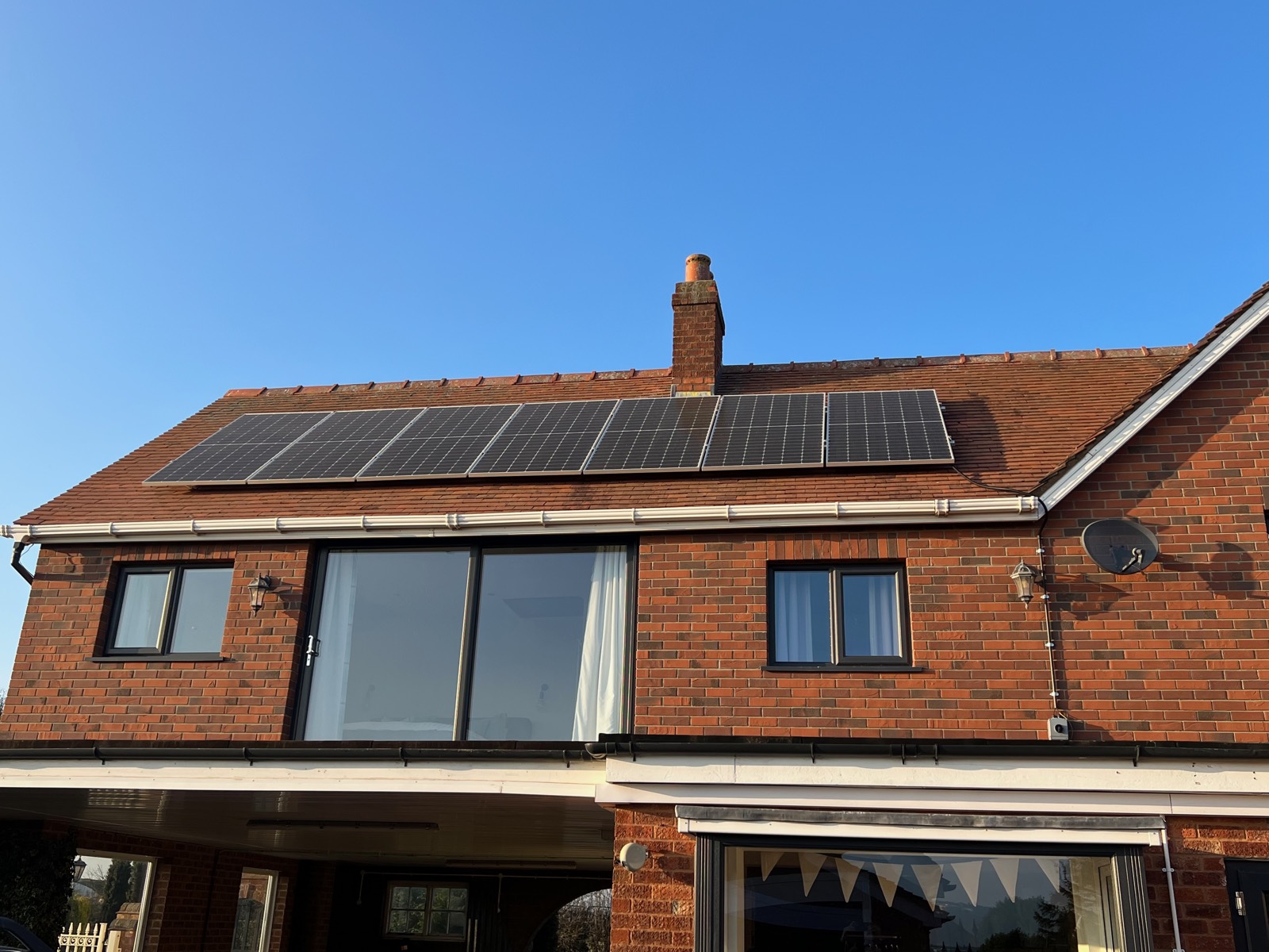 All-black panels sitting just proud of a tiled roof — a clean on-roof finish.